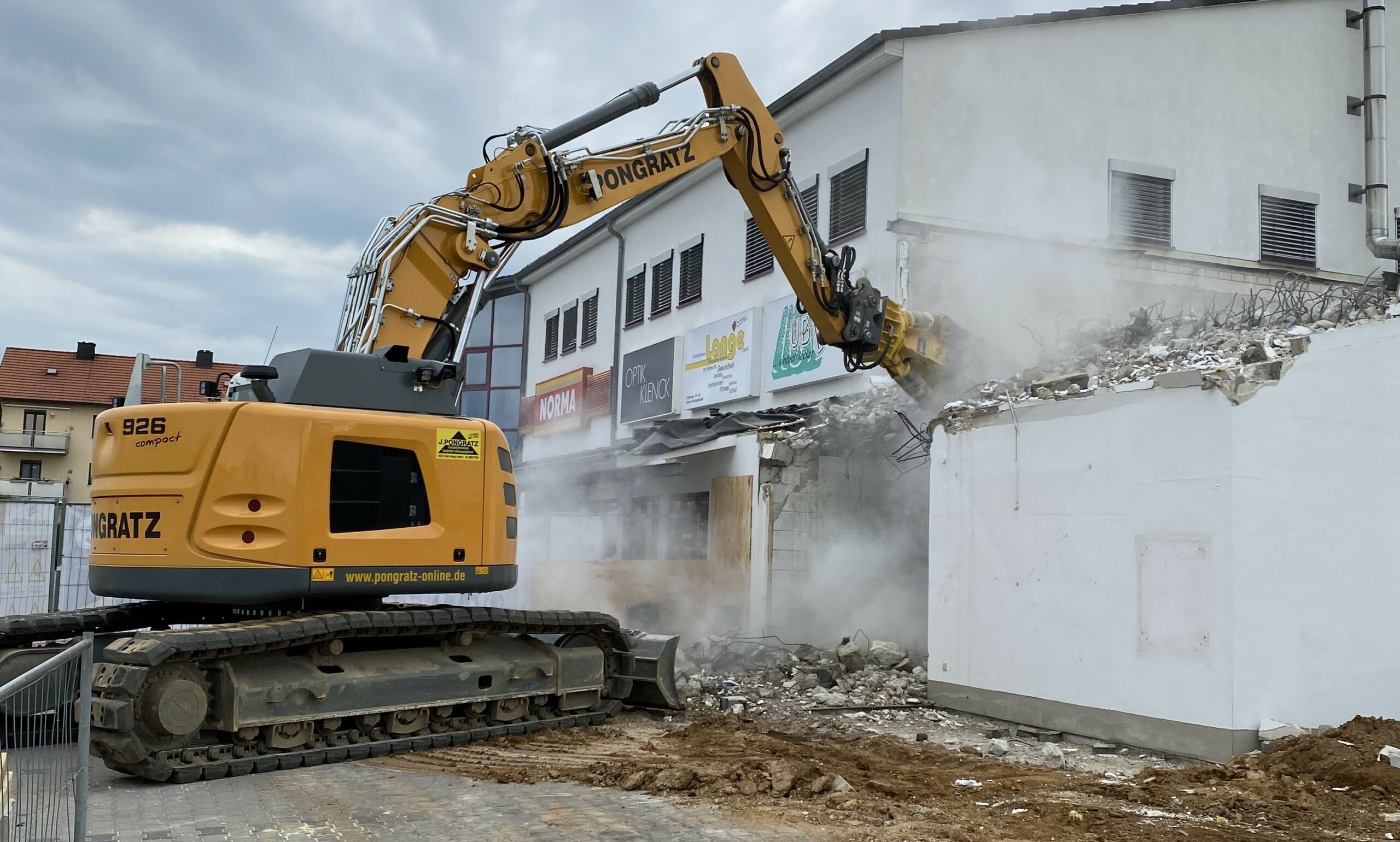Ein Bild, das zwei Bagger und einen LKW der Firma Pongratz bei den Abbrucharbeiten eines Wohngebäudes in Vilseck (Oberpfalz) zeigt.